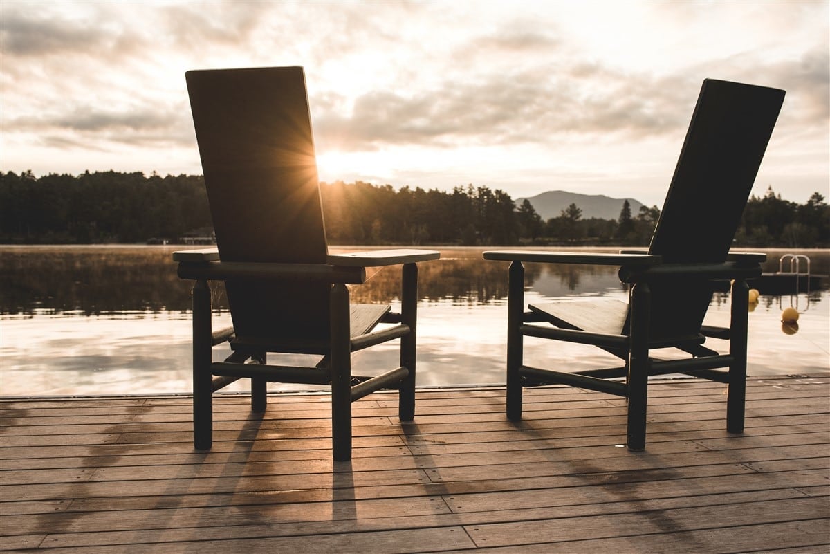 Relax on the shore of Mirror Lake two chairs on the dock at sunrise