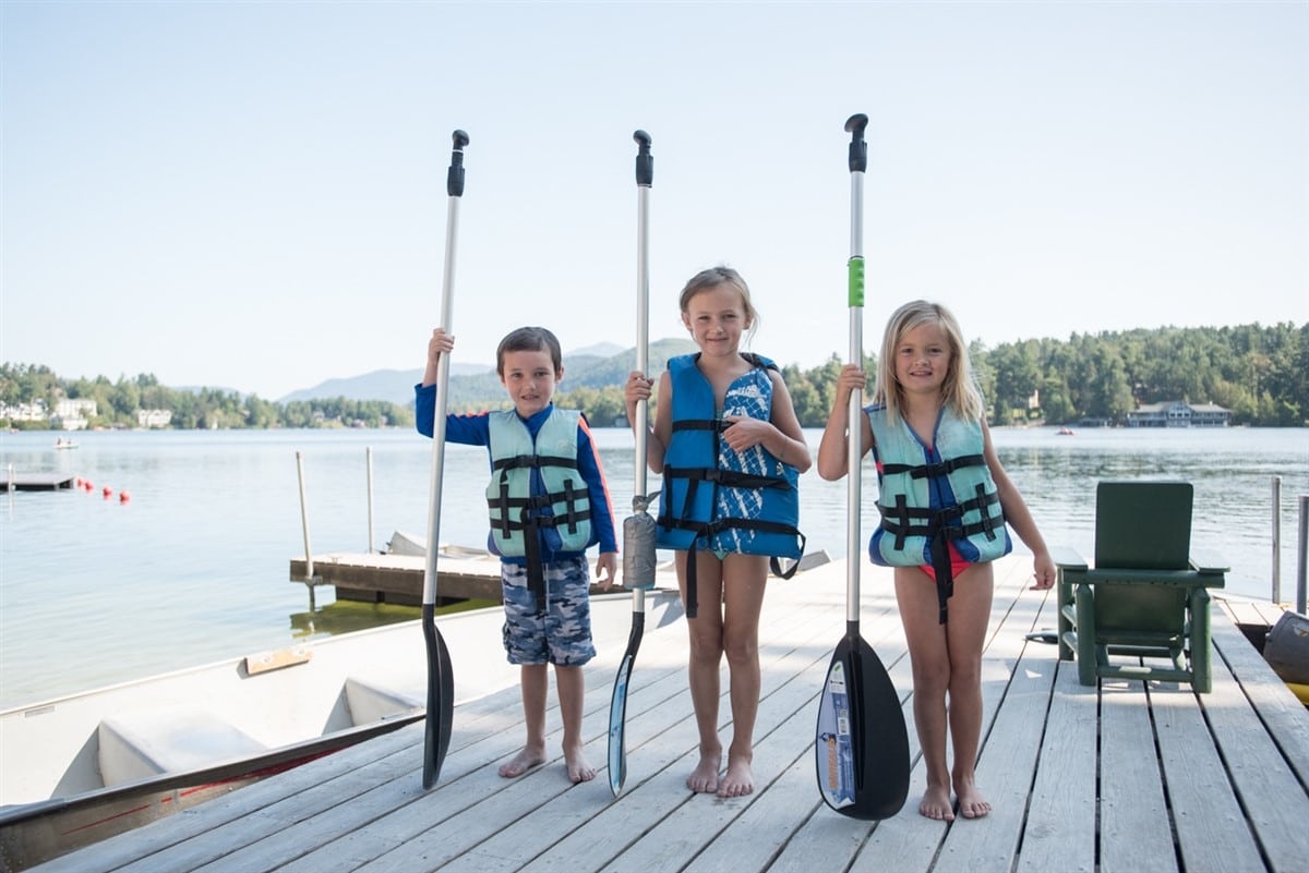Complimentary Kayaks, Rowboats, SUPs, Canoes & Paddleboats for Guests 3 kids standing on the dock with paddles