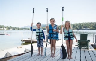Kids with paddles on the dock