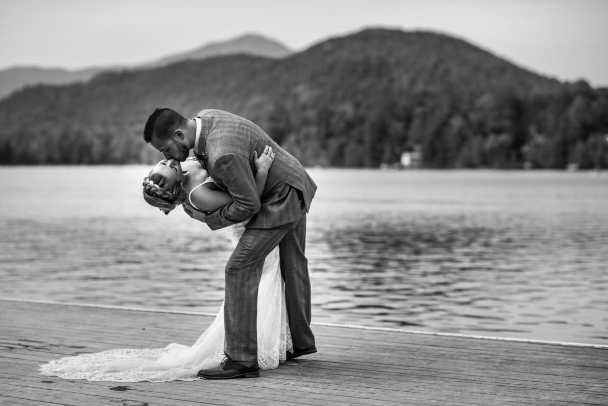 bride and groom kissing on dock