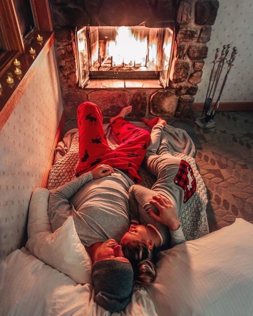 couple laying by the fire in matching pjs