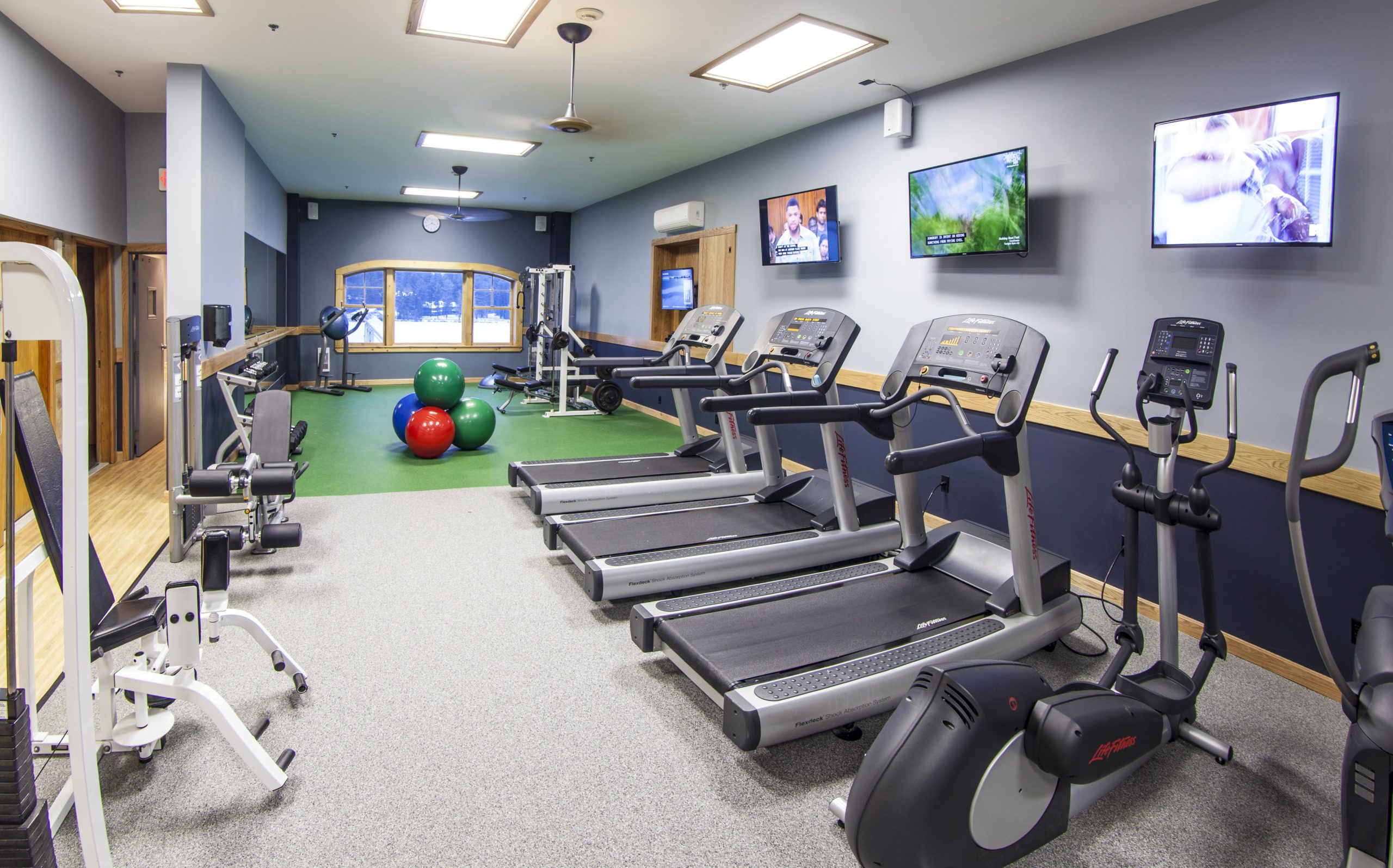 fitness center with treadmills and weights