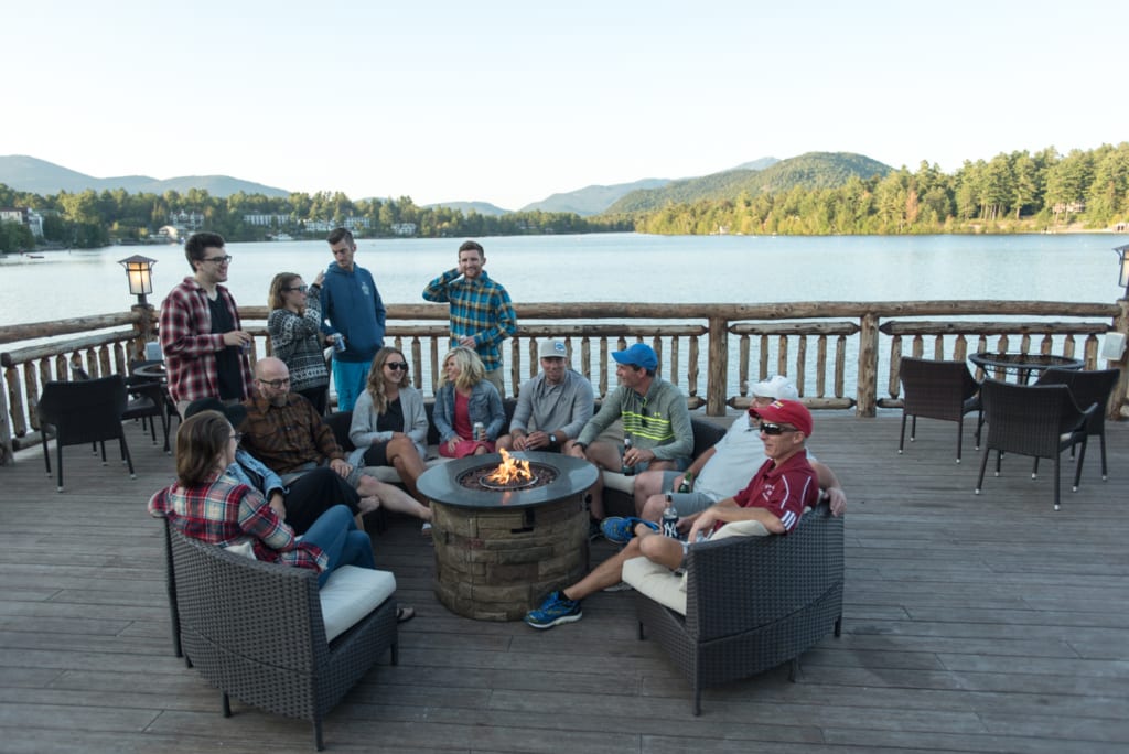 friends hanging out by firepit on boathouse