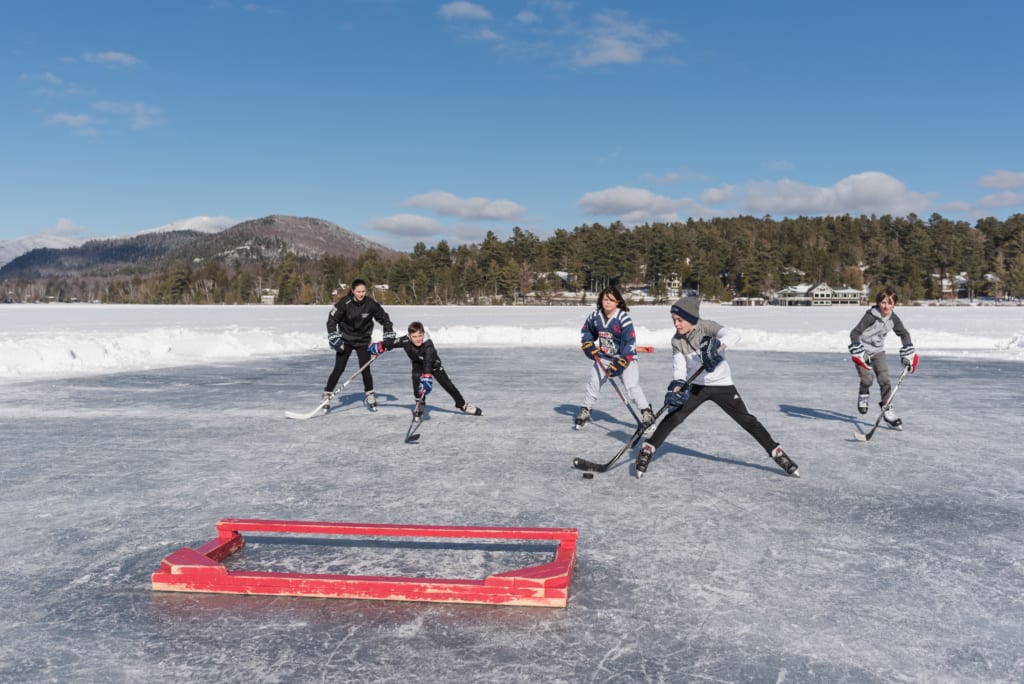 kids playing hockey on lake