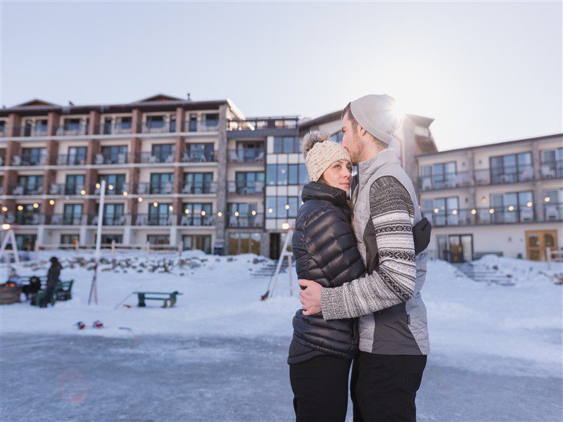 Winter Couple Couple hugging on ice outside of hotel