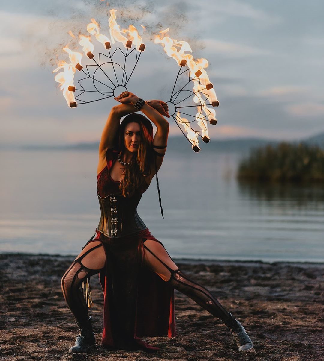 Woman on a lake shore with torches