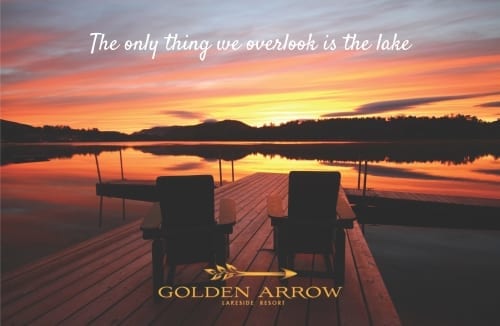 Adirondack chairs on Mirror lake dock at sunset. Text: The only thing we overlook is the lake.