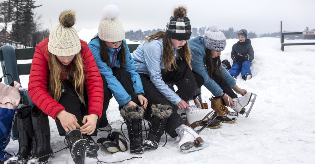 Kids lace up their skates on Mirror Lake