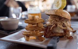 Wolfjaw burger with bacon, cheese, and onions with a side of fries