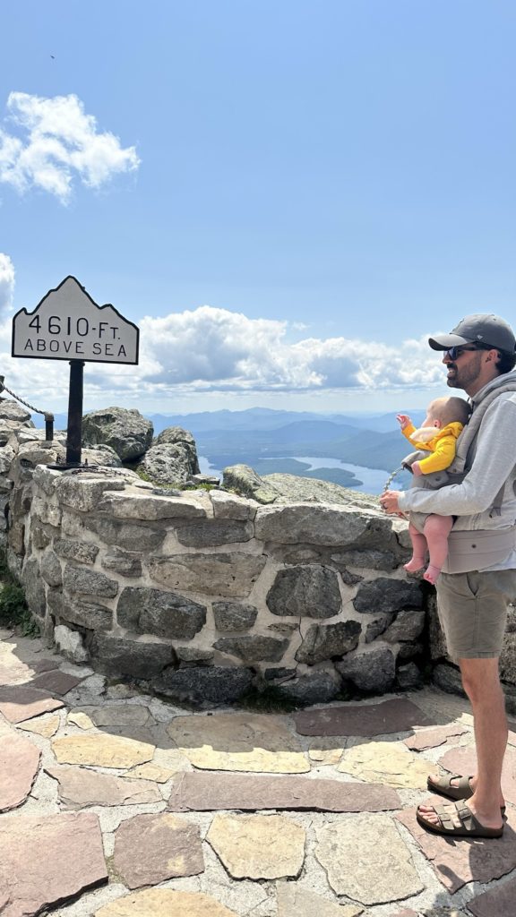 Guy with baby looking at Whiteface Elevation Sign at Memorial Highway